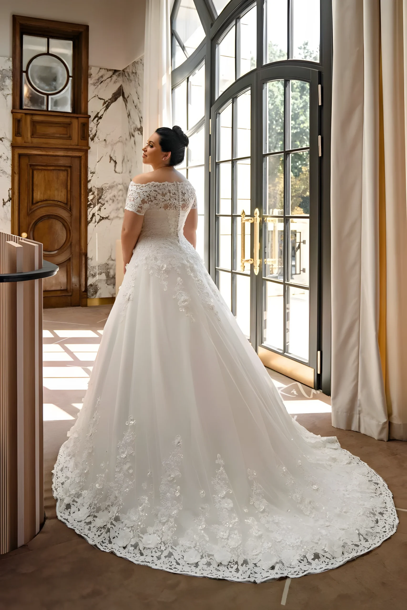 Robe de mariée grande taille au dos couvert par voile de dentelle