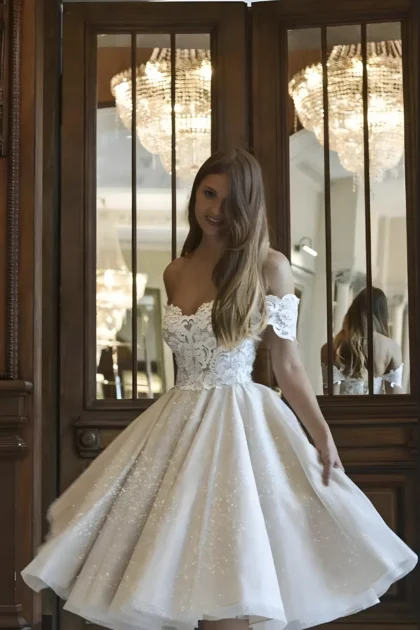 Robe de mariée évasée en tulle avec tombé sous genoux. Une tenue de noce brillantes avec corset en dentelle.