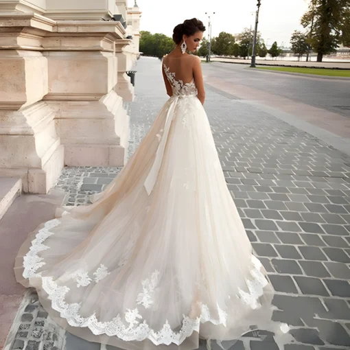Robe de mariage couleur champagne dos nu caché derrière tissu illusion avec délicats imprimés de dentelle
