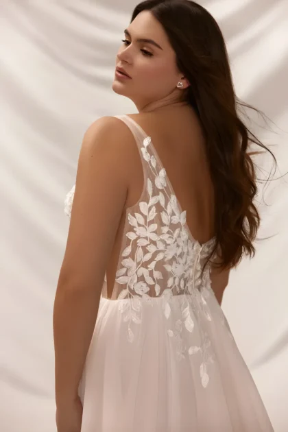 Robe de mariée avec dos ouvert qui se cahe derrière un tissu illusion couvert d'appliques